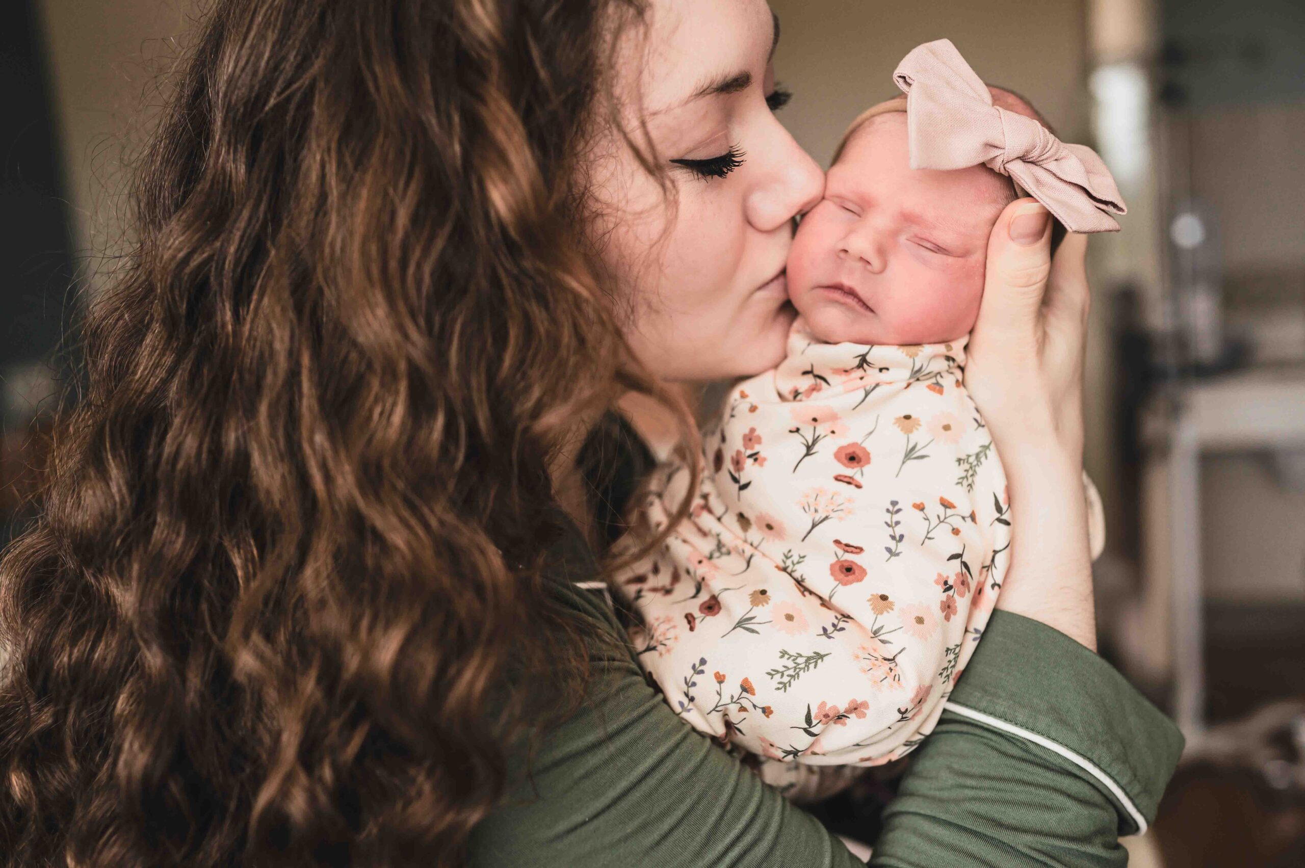 mom kisses her newborn on the cheek