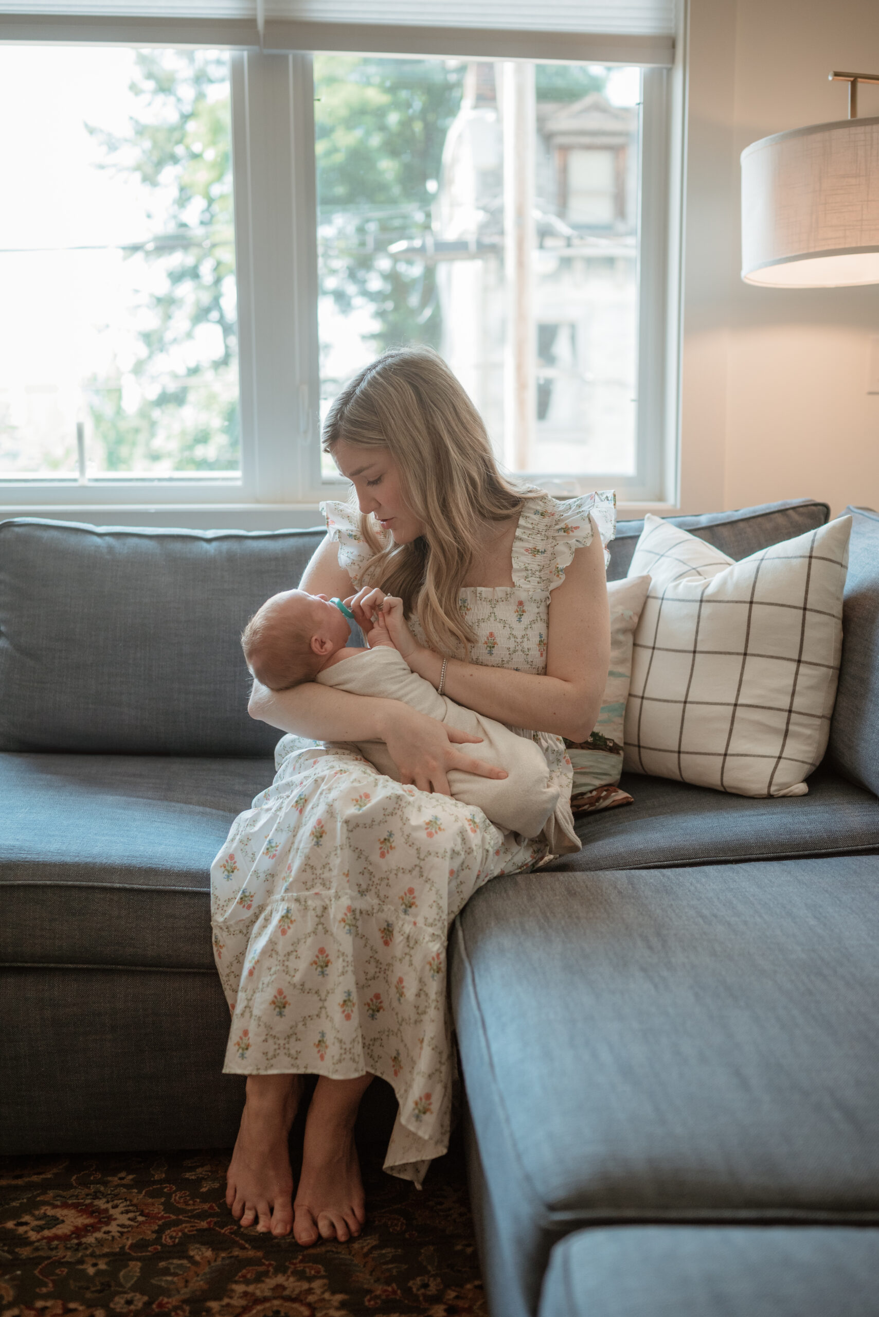 first time mom rocking and soothing her baby in her north side, pittsburgh pa home